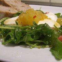 Heisses melonen chutney liebt ziegenkäse auf rucola-bett