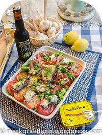 Salat mit tomaten, knoblauch und ölsardinen in olivenöl mit zitrone