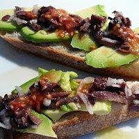 Avocado mit anchovis und vinaigrette aus schwarzen oliven