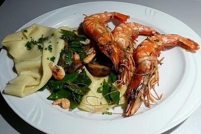 Black tiger prawns auf flusskrebsen mit zuckerschoten zwischen offenen ravioli
