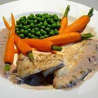 Steinbutt an weißweinsauce mit karotten und erbsen