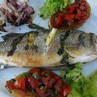 Wolfsbarsch gegrillt mit Knoblauchknollen und Bruscetta