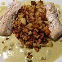 Zackenbarsch mit kartoffeln auf knoblauchsauce mit wildkräutersalat