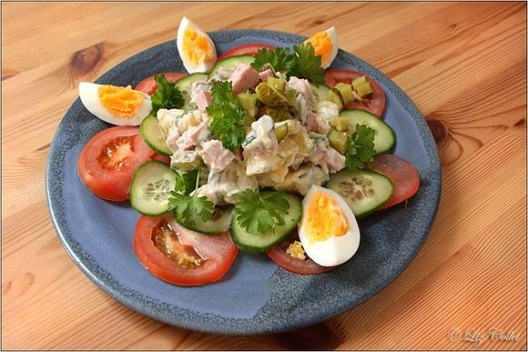 Bunter kartoffelsalat mit leberkäse, gurken und petersilie