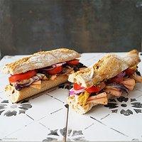 Baguette mit einer senf-dattel-crème, in knoblauch geschmortem radicchio, tomaten und roter zwiebel und chili extra aufschnitt