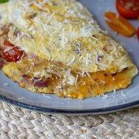 Fluffiges ome­lett mit parmesan, cocktailtomaten, zwiebeln und knoblauch
