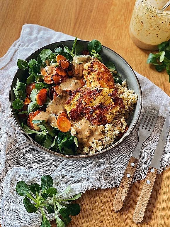 Hähnchen bowl mit bulgur, feldsalat, karotten und mandelsoße