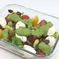 Salat aus kirschtomaten und büffelmozzarella mit rucolapesto