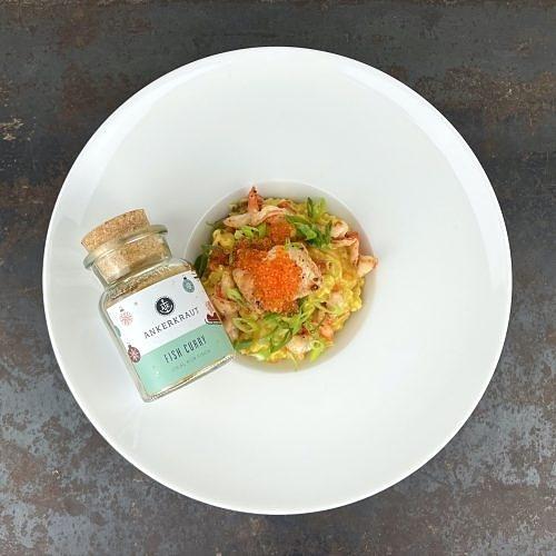 Fisch-curry-risotto mit lachs, scampi und forellenkaviar