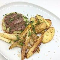 Rib-eye-steaks mit gebratenen spargel, kartoffelchips und spargelhummus