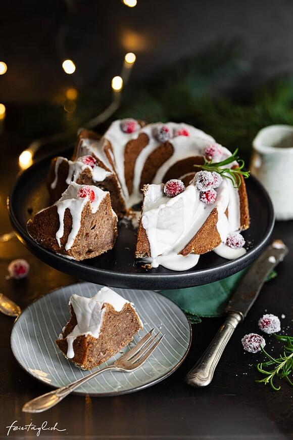 Saftiger lebkuchen-gugelhupf mit zuckerguss und glitzernden cranberries