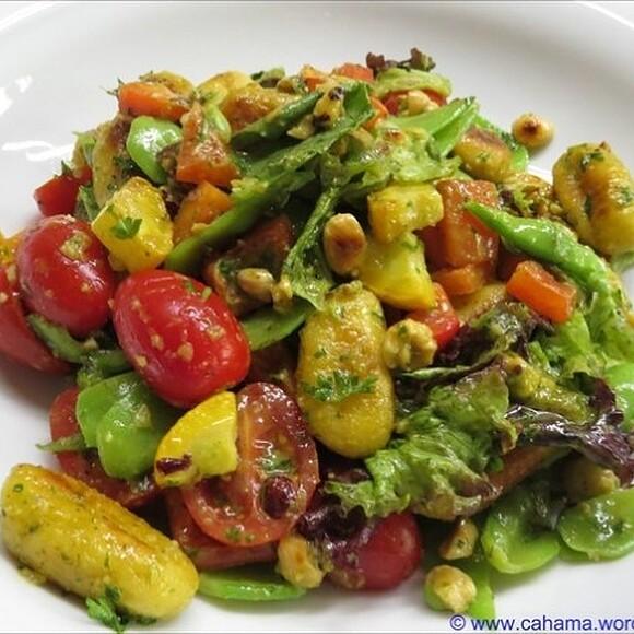 Mediterraner gnocchi-salat mit pesto und gerösteten haselnüssen