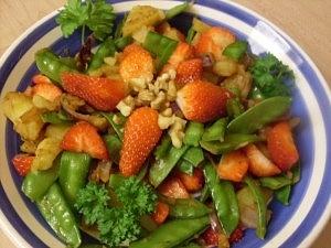 Scharfe kartoffelpfanne mit zuckerschoten und erdbeeren vegan
