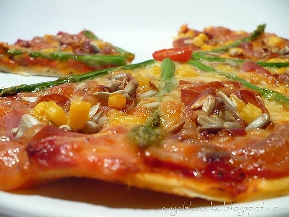 Pizza mit grünem spargel, parma-schinken und sonnenblumenkernen