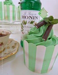 Mintfarbene Minzcupcakes mit Minzsirup im Topping und minziger Deko
