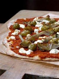 Vorbereitetes fast-food: flammkuchen mit muhammara, artischocken und ziegenfrischkäse