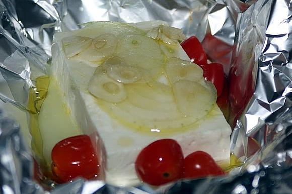 Gedünsteter schafskäse mit tomate und zwiebel